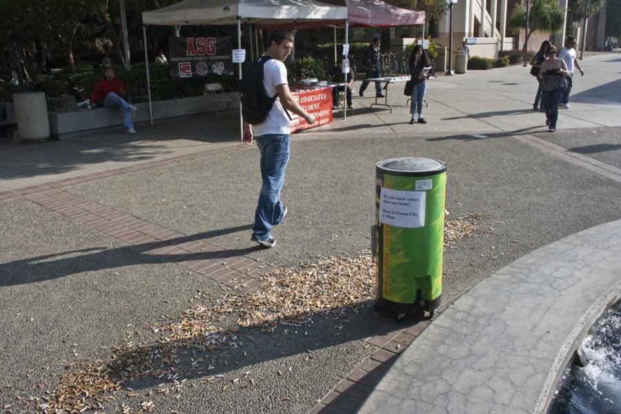 Freshman George Prountchenko  takes a long look at the Cigarette Butts that were put on display by ASG on nov. 17
