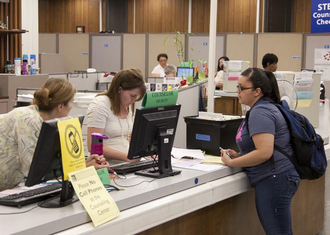 Counselor Kayla Mannon helps a student with registration issues. From the Rampage Archive.