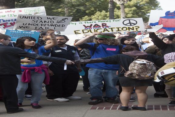 Peacekeepers hold hands to prevent protesters from advancing on to the capitols steps in Sacramento March 4. (Photo/Darlene Wendels)