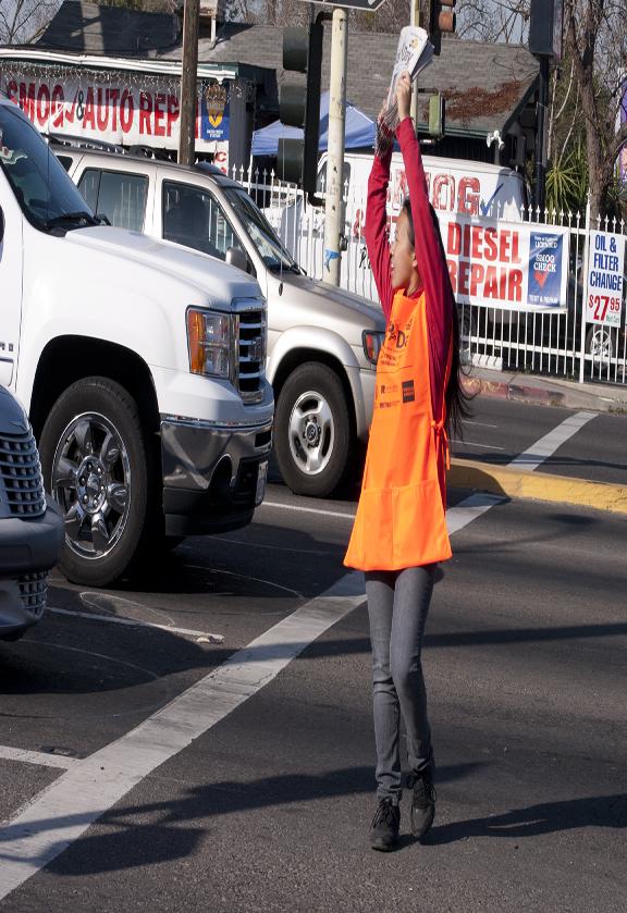 Lee Xiong, member of the Hmong American Student Association crosses the intersection of McKinley and Blackstone to help the Kids Day Fundraiser March 5 (Photo/Karen West).