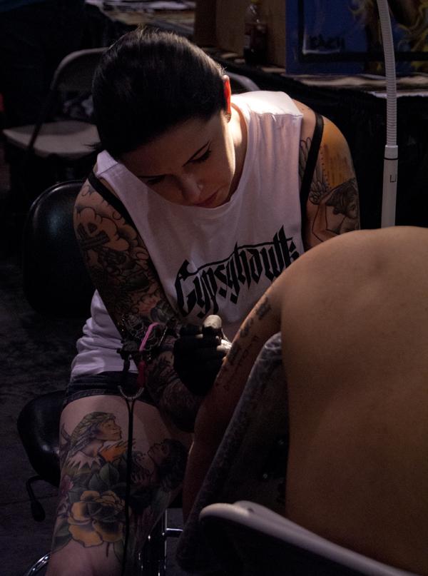 Tattoo artist, Nikki Sin Constalupes, doing a tattoo during the Fresno Tattoo Convention on April 27, 2013. Nikki Sin has been coming to the Fresno Tattoo Convention for three years and said, ...actually its one of my favorite conventions to work at... Nikki Sin works at Valor Parlor in Reno, Nev. (Photo/Karen West)
