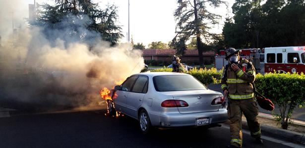 Fireighters arrive on scene as a parked 1999 Honda Civic is in flames in a Fresno City College parking lot next to Van Ness Ave on Thursday, Sept. 12, 2013.