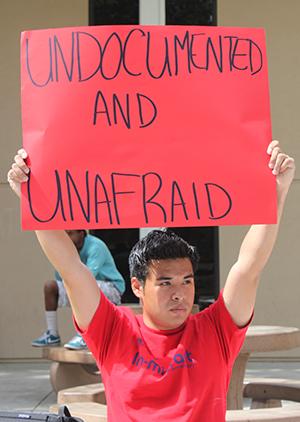 Angel Sanchez holds signs in support of immigration reform in the Free Speech area at FCC for the Students Without Borders event “Coming out of the Shadows,” Tuesday, March 25, 2014. Photo/Desiree Aranjo