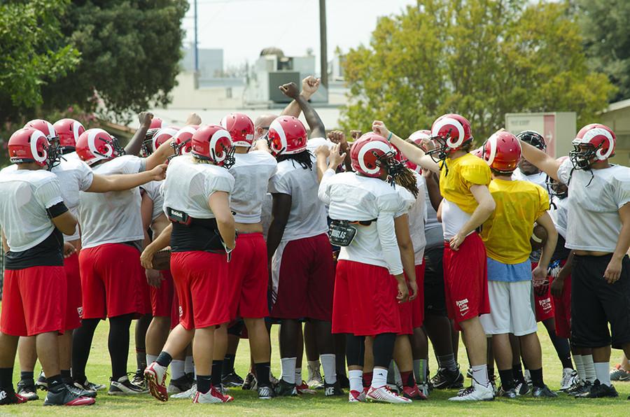 The Fresno City College football team huddles  for support  before their practice. 