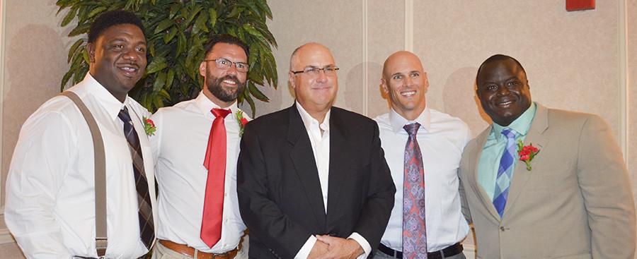 Former FCC football players (from left to right)) Tracey Hunt, Sean Soares, Matt Giordano, and Earl Charles stand with (Middle) Head Coach Tony Caviglia as they are honored at the 26th annual Wall of Fame. 