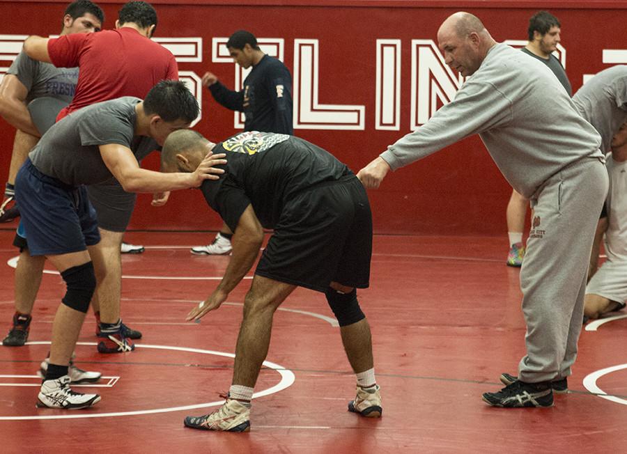 Choach Paul Keyshawn teaching proper technique to Sebastian Setowski and Amir Jon Naser in the Wrestling room on Thursday, Sept. 10, 2015. 