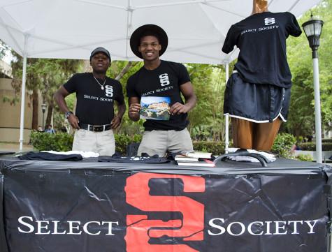 Femi Olukanni Jr. (right) and Emerald Thomas (left) display merchandise from Select Society Clothing Brand at the FCC Art Hop Oct. 1,2015.