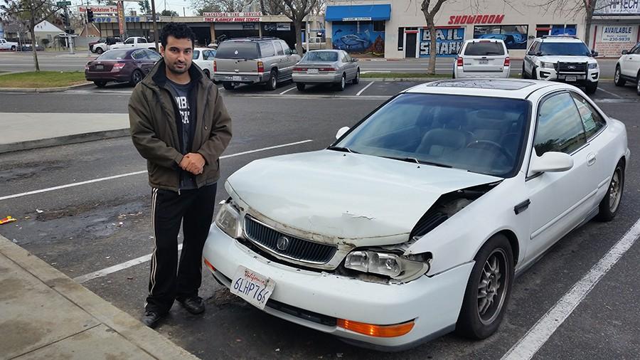Rami Abed stands next to his car on Jan. 13, 2016 after a carjacking suspect crashed into him twice. 