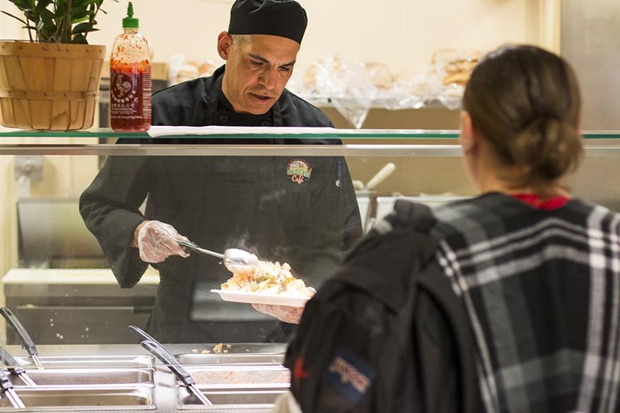 A Fresno City College Cafe chef serves food to students at the college cafeteria on March 8. Campus eateries have a history of extensive inspection violations. 