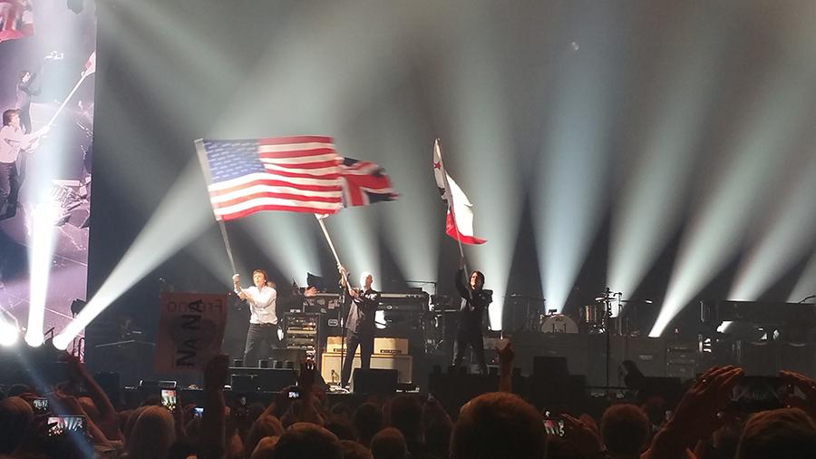 Paul McCarney and his band mates wave flags of the United States, the United Kingdom and of the California State Flag at the Savemart Center in Fresno, California on April 13, 2016. 