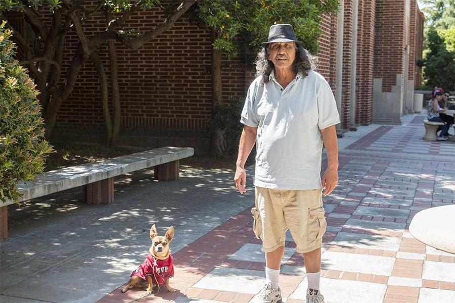 Larry Rodriguez stands next to his dog, Zapata outside the Fresno City College Library building on April 13, 2016. Rodriguez says his pet dog helps him get through college. Rodriguez and Zapata have become familiar faces on campus. 