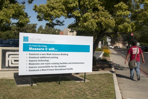 A student walks near a State Center Community College District billboard promoting Measure C at the southeast entrance to Fresno City College on April 18, 2016.