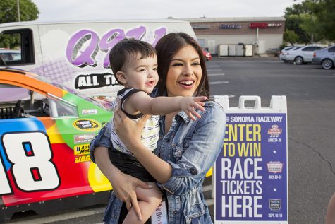 Kimberly Marquez stops to take a picture with a young listener during a "remote" for Q97.1 FM at Save Mart in Clovis, Calif. on May 4, 2016