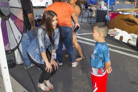 Kimberly Marquez take a moment to talk with a young listener during a "remote" for Q97.1 FM at Save Mart in Clovis, Calif. on May 4, 2016