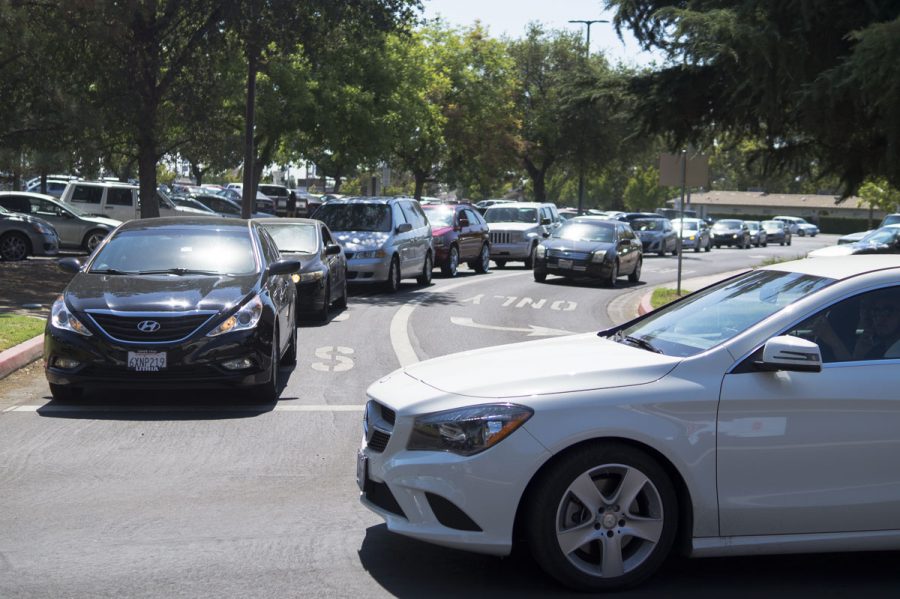 Cars line up on the road from the McKinley entrance as students attempt to find parking at Fresno City College on Aug. 15, 2016.