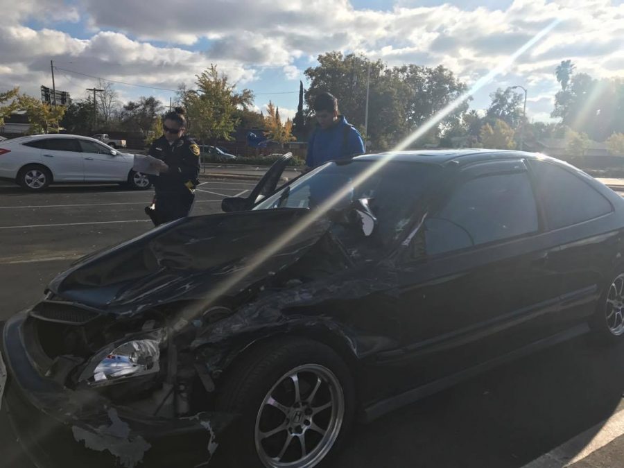 A State Center Community College District police officer writes information after Fresno City College Jesus Anguiano crashed into three cars on Monday, Nov. 21, 2016. 