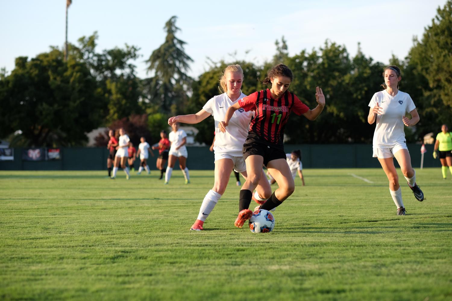 Franki Navarro covers the ball from Cyprus College players during their home opener on Wednesday, Sept. 6, 2017.