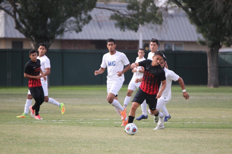 Fresno City College Defender  Matheus Araujo keeps the ball way from opposing players from Modesto Junior College on Tuesday Oct. 10 , 2017.