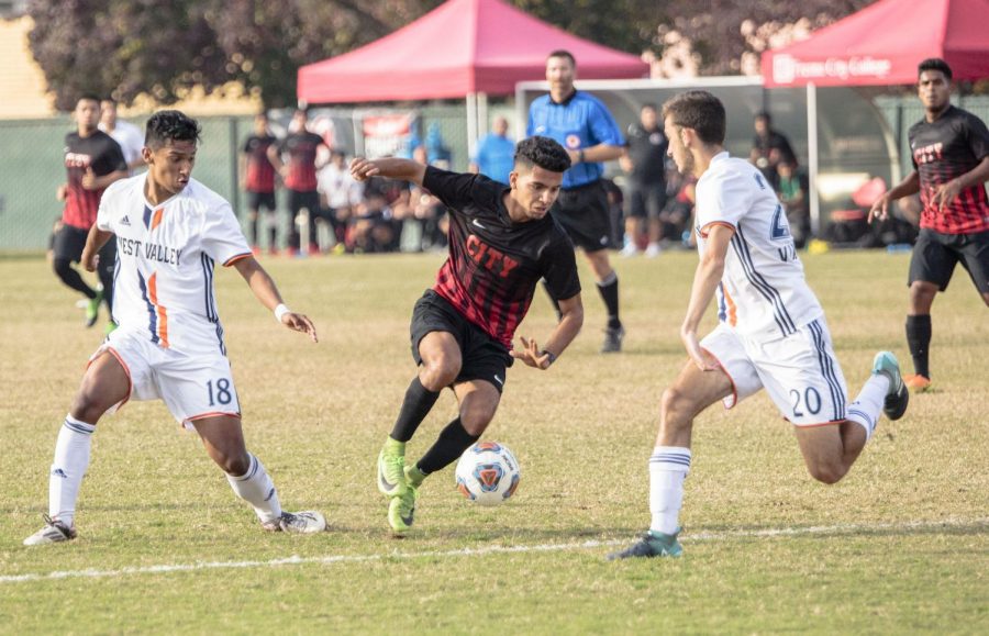 Fresno City College forward Manual Lopez takes on two West Valley defenders during their playoff game at home on Saturday, Nov. 25, 2017.