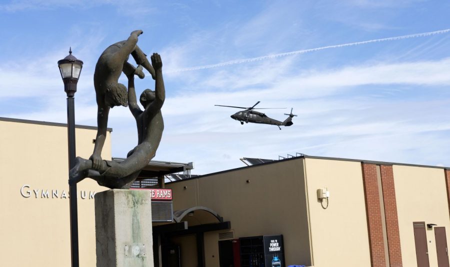 A Blackhawk helicopter flies over the crowd during the Veterans Day ceremony outside the cafeteria on Friday, Nov. 3, 2017