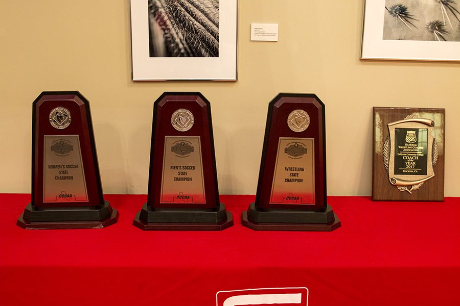 The three state championship trophies for womens soccer; mens soccer and wrestling alongside coach Keysaws coach of the year award.