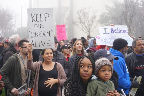 People hold signs and gather around Fresno City Hall on Monday, Jan. 15, 2018 to commemorate Martin Luther King Jr. and his legacy.