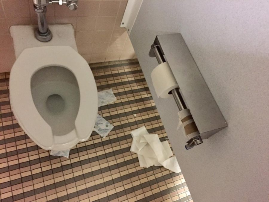 Trash lies on the floor inside the middle stall of the women's restroom by the cafeteria/student lounge on Tuesday, Feb. 13, 2018.