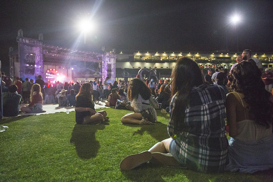 A crowd sits on the grass at Grizzly Fest 2017, Saturday night on April 29, 2017. Participants sat on the grass to enjoy music, food and drinks or when a break was needed.
