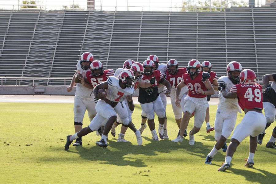 Wesley Graves rushes past the defensive line during a hand off drill during practice at Ratcliffe Stadium on Tuesday, Aug. 28, 2018. Photo by Larry Valenzuela