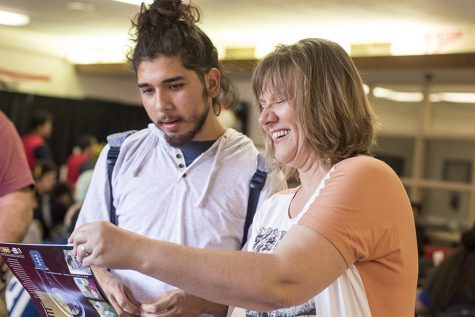 Geologic Science instructor Alexandra Priewish shows a student some information about joining the Geolgy Club at Student Activities very first Open House event in the student lounge on Wednesday, Aug. 22, 2018.