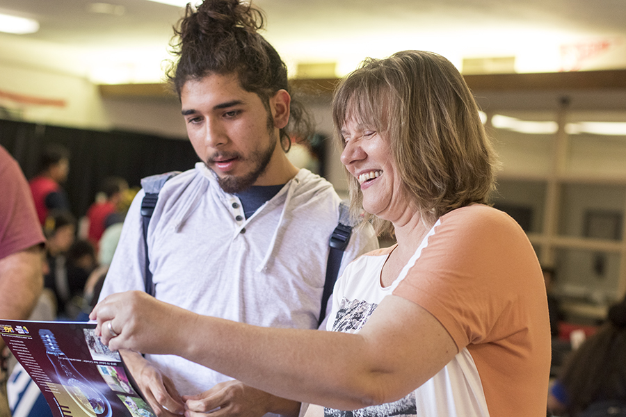 Geologic Science instructor Alexandra Priewish shows a student some information about joining the Geolgy Club at Student Activities very first Open House event in the student lounge on Wednesday, Aug. 22, 2018.