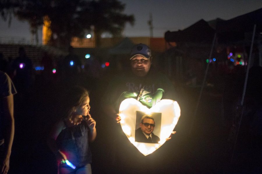 Participant holds up a sign during the silent walk for the Relay for Life at Ratcliffe Stadium on Saturday. Sept. 8, 2018.