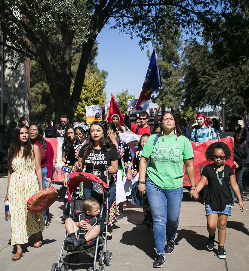 Students hold up signs and march to the fountain area to celebrate Indigenous peoples Day on Monday, Oct. 8, 2018.