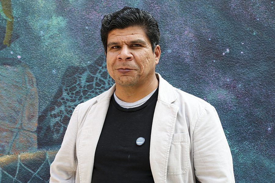 Fresno City College art professor Ricardo Rivera in front of a mural in Fresno City College on Tuesday, Nov. 20, 2018.  Rivera poses social commentary on racism, classism and discrimination through his artwork. 