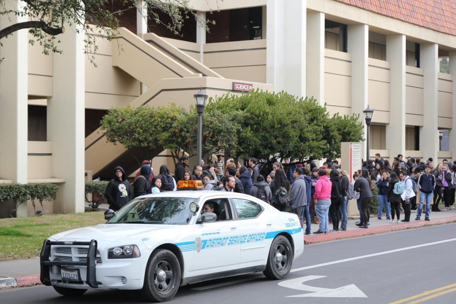 Campus police pass by students after evacuating the math and science building on campus following a possible gas leak on Feb. 12, 2019. 