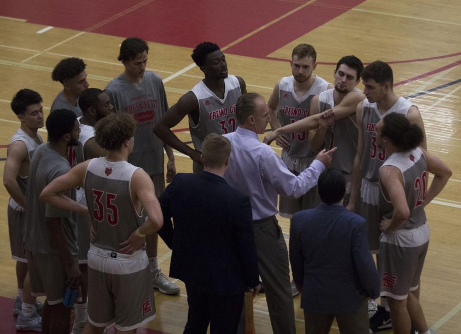 The Rams Men's basketball team surrounds head coach Ed Madec as he prepares them for the second half of their round 2 regional playoff game against Sacramento City College on March 2, 2019.