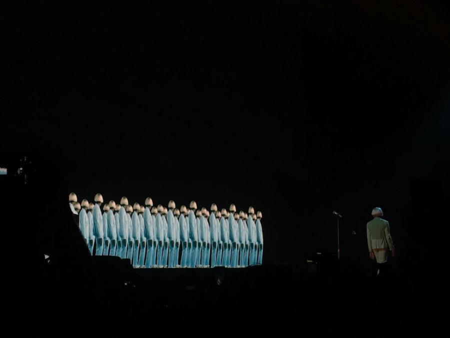 Tyler the Creator (right) walks across the stage while an army of Tylers appear on the screen behind him. 