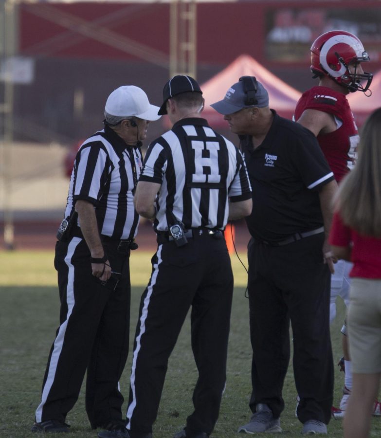 Rams head coach Tony Caviglia meets on the sidelines with referees during a timeout in the Rams game against American River College on Oct. 5, 2019. The Rams went on to lose the game by a score of 9-3.