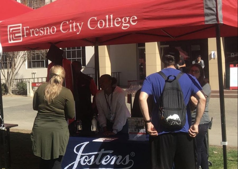Students approach the Jostens cap and gown booth. The grad fair was an opportunity to check out the prices of caps and gowns.