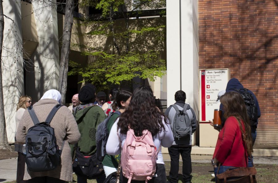 Faculty and students gather outside the Music/Speech building following a potential gas leak which prompted an evacuation shortly after noon on Wednesday, March 13.