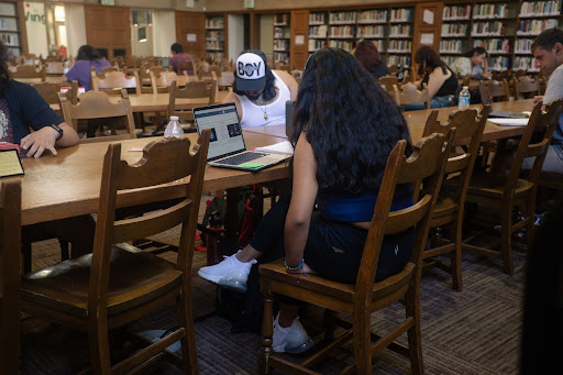 A Fresno City College student reading a lecture on a laptop and taking notes on her notebook at the library on Aug. 28, 2023.