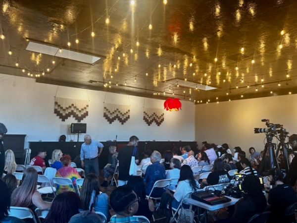 Audience members filling into seats at Tower Yoga: Lotus Room to watch Poet Laureates Lee Herrick and Juan Felipe Herrera on October 14, 2023. 