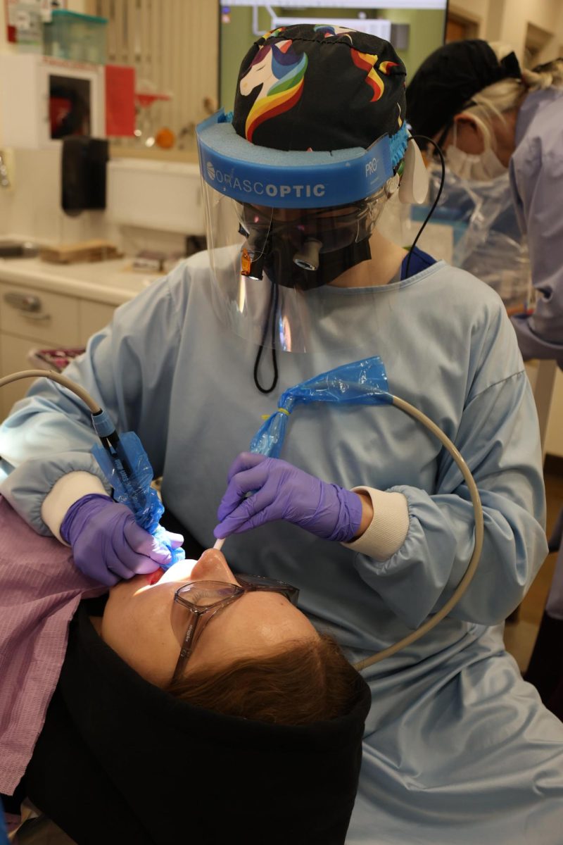 Victoria Horne, a dental hygienist student, cleans her friend Rhonwyn Groger’s teeth on Nov. 22.