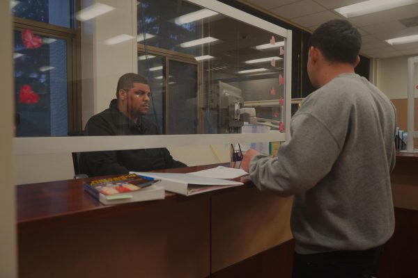 Financial Aid Specialist Israel Kinlow assists Alexander Muniz with questions.