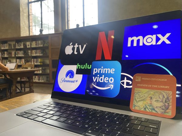 A staged photo of an open laptop that displays several streaming service logos in the Fresno City College library on January 31, 2024, with a “Friends of The Library” coaster that can be found around each table.