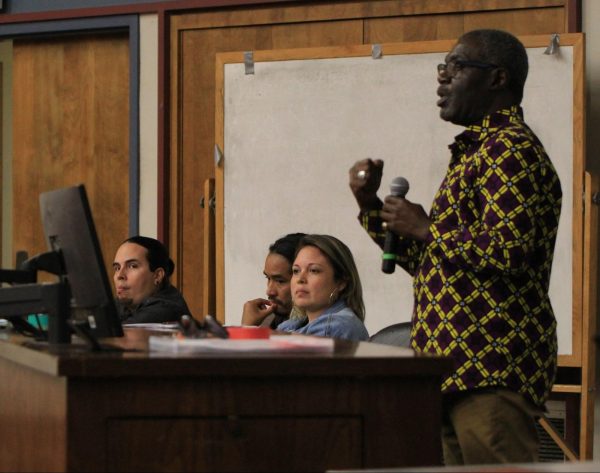 (Right to Left) Auguste Kouadio speaks to the audience as Victoria Benavides, Rigoberto Garcia, and Eric Escovedo sits alongside him.
