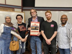 (left to right) Rawan Kiran, Linda Renland, Paul Gilmore, Michael Workman and Matthew Gillian pose for a picture with a promotional poster for the Fresno City College’s screening of “The Encampments” in the Forum Hall-101 on May 15, 2025.