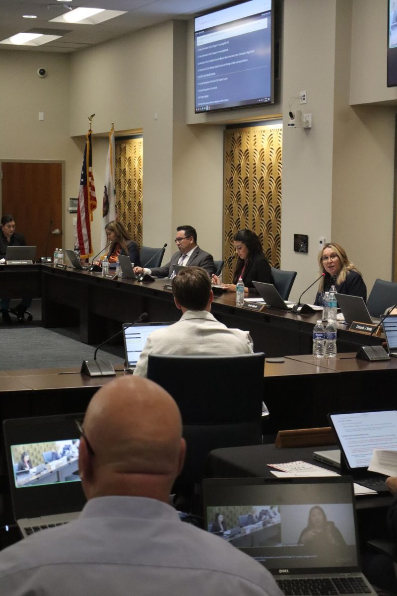 A video-switcher for the State Center Community College
District Board of Trustees meeting watches over the meeting
and monitors his computer for viewers watching from home
through Zoom on May 6, 2025.