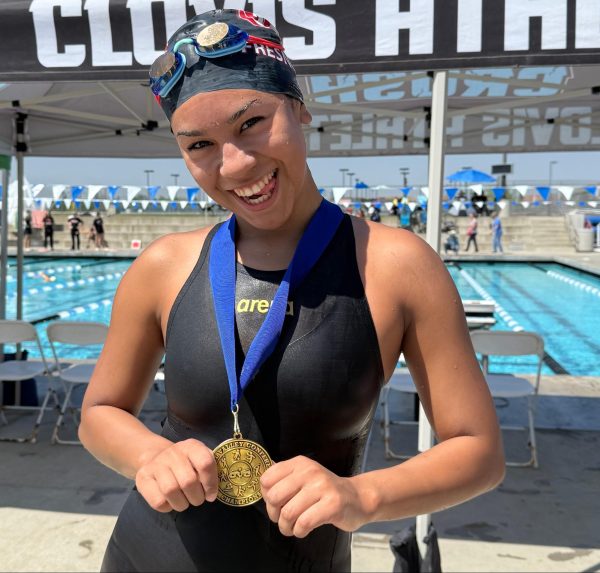 Fresno City College freshman swimmer Natalie Mares smiles as she poses for a photo with her medal for receiving first place in the mile event on April, 19 2025
