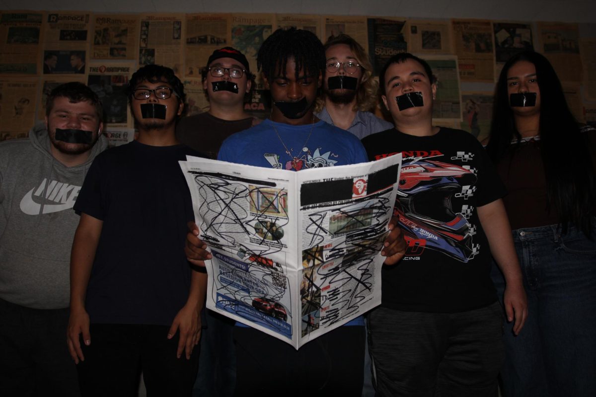 Rampage editors (left to right) Justin Shaw, Joel Arellano, Gavin Ruland, Jimmy Johnson, Logan Payne, Juan Muratalla and Angelina Alatorre-Amaya pose for a photo in the Rampage newsroom with duct tape covering their mouths as Johnson holds a scribbled and censored Sept. 10 Rampage newspaper.